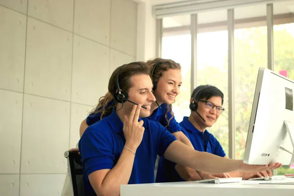 Centre staff worker team with headphones working together at call center service desk consultant, helping, training and motivating colleague to improve customer service, cheer up teamwork service mind and happy workplace concept