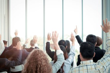 İş adamları seminer konferansında konuşmacı ile soru sormak için el kaldırıyor, anlaşmak için el kaldırıyor veya toplantıda yorum için oy veriyorlar