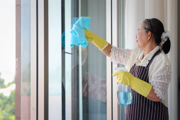 아시아 의연로 주부들 장갑을 스프레이 창문닦기를 청소를 할머니가 청소를 유리를 — 스톡 사진