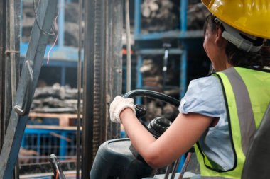 Fabrika imalatında forklift kullanan endüstriyel işçi kadın, Asyalı güzel kadın mühendis ve arka planda bulanık motor parçaları.