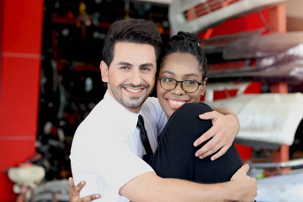 Happy Harmony people at workplace, smiling white man and African American worker hugging each other showing love and respect in differences of race skin color, embracing cultural diversity in the workplace, divers people can work together