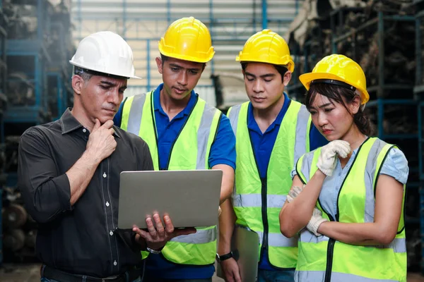 工业工程师男女工人头戴头盔 与制造厂的笔记本电脑计算机进行讨论和合作 还有在工业界工作的年轻人 — 图库照片
