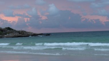 Romantik deniz gündoğumu, parlayan altın bulutlu gökyüzü ve sahile doğru hareket eden okyanus dalgaları, sabah tropikal yaz plajlarında gün doğumunun muhteşem doğal manzarası. Koh Samet Adası, Tayland    