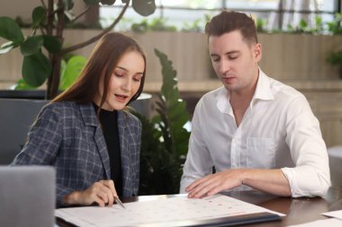 Modern ofis ya da kahve dükkanının lobisinde oturan mutlu iş arkadaşı, birlikte çalışan çekici iş ortağı, iş projesi hakkında sohbet eden ve tartışan. 