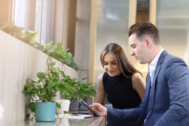 Modern ofis ya da kahve dükkanının lobisinde oturan mutlu iş arkadaşı, birlikte çalışan çekici iş ortağı, iş projesi hakkında sohbet eden ve tartışan. 