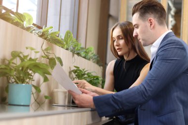 Modern ofis ya da kahve dükkanının lobisinde oturan mutlu iş arkadaşı, birlikte çalışan çekici iş ortağı, iş projesi hakkında sohbet eden ve tartışan. 