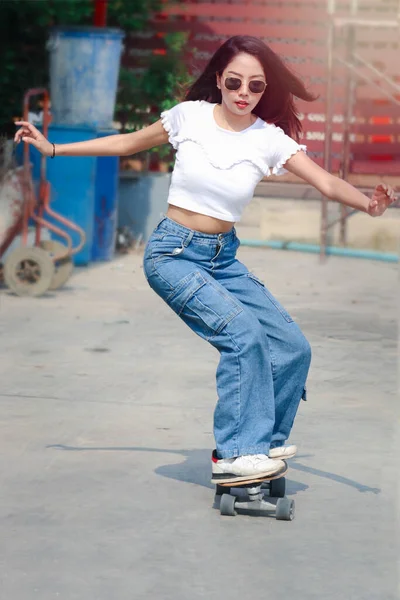 선글라스를 밖에서 파도타기 아름다운 아시아 여성은 야외에서 스케이트보드를 극단적 스포츠 — 스톡 사진