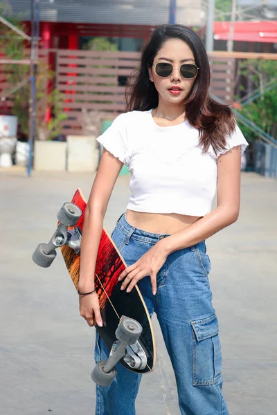 선글라스를 밖에서 보드를 노상에서 파도타기를 아름다운 아시아 여자는 야외에서 스케이트 — 스톡 사진
