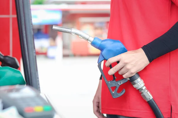 Asistente Gasolinera Uniforme Rojo Sosteniendo Una Boquilla Bomba Gasolina Contra —  Fotos de Stock