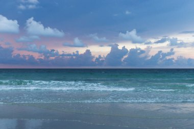 Romantik deniz gündoğumu, parlayan altın bulutlu gökyüzü ve sahile doğru hareket eden okyanus dalgaları, sabah tropikal yaz plajlarında gün doğumunun muhteşem doğal manzarası. Koh Samet Adası, Tayland    