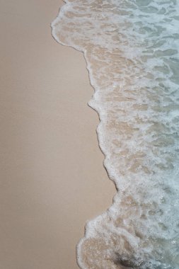 Tropikal yaz kumsal arka planının güzel doğal manzarası. Mavi okyanus dalgaları beyaz kumsal adasına çarpıyor..