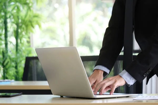 Businessman hands working with laptop computer at office working desk.