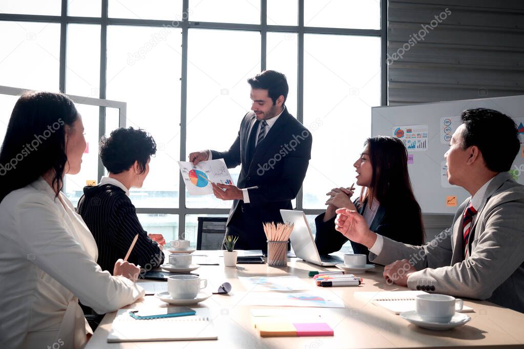 Achievement successful young smart businessman sharing his experience success and giving presentation at conference meeting desk, five businesspeople having discussion about project work in office at the morning, people at workplace