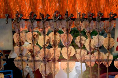 Tayland sokak yiyecek pazarı, bir sıra kurutulmuş mürekkep balığı, egzotik yiyecekler.  