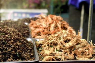 Kızarmış tatlı su yengeci ve böcekler Tayland sokak yiyecek pazarında atıştırmalık olarak satılıyor, egzotik yemekler yüksek protein öğünleri  