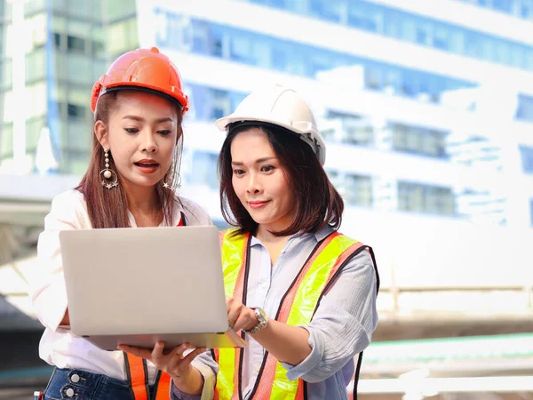 Две Молодые Красивые Азиатские Женщины Инженеры Защитном Жилете Шлеме Используя — стоковое фото