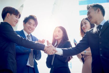 Genç Asyalı başarı grubu başarılı iş adamları imza üstüne imza atarak el sıkışıyor, şirket grubu el çırpıyor ve iyi sonucu takdir ediyor, iş adamı ve kadın şehir dışında buluşuyorlar..