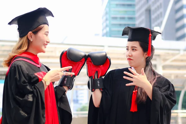 Duas Mulheres Graduadas Felizes Estudantes Aquecendo Chapéu Acadêmico Quadrado Com — Fotografia de Stock