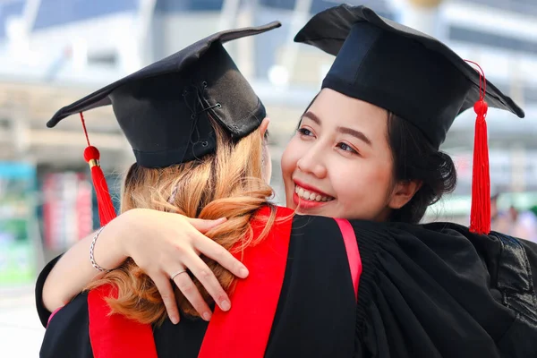 Duas Estudantes Graduadas Felizes Com Chapéu Acadêmico Quadrado Boné Abraçando — Fotografia de Stock