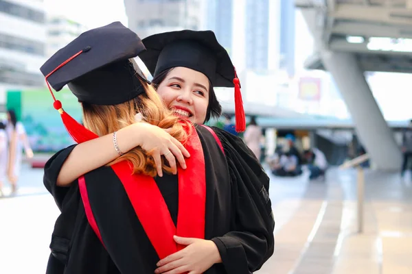 Δύο Ευτυχισμένες Απόφοιτες Φοιτήτριες Τετράγωνο Ακαδημαϊκό Καπέλο Αγκαλιάζονται Άνθρωποι Γιορτάζουν — Φωτογραφία Αρχείου
