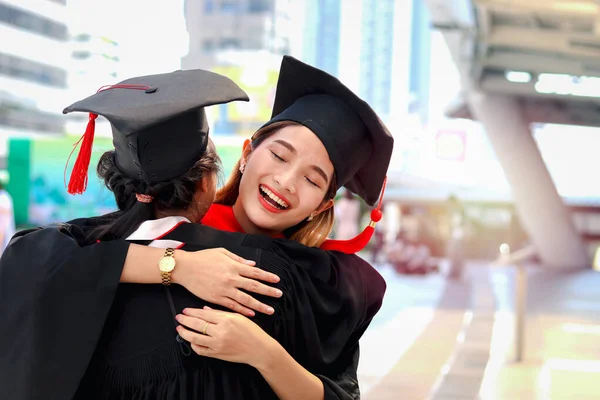 Duas Estudantes Graduadas Felizes Com Chapéu Acadêmico Quadrado Boné Abraçando — Fotografia de Stock