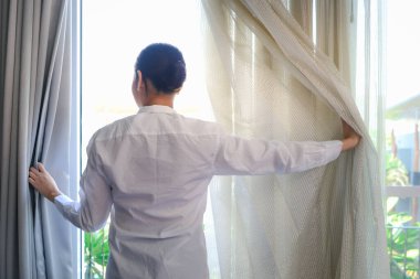 Genç ve yakışıklı garson kafenin camlarını silmek için sprey tutuyordu. Restoranı temizliyordu. Gülümseyen işçi kameraya doğru püskürtüyordu..