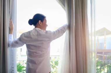 Genç ve yakışıklı garson kafenin camlarını silmek için sprey tutuyordu. Restoranı temizliyordu. Gülümseyen işçi kameraya doğru püskürtüyordu..