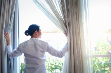 Genç ve yakışıklı garson kafenin camlarını silmek için sprey tutuyordu. Restoranı temizliyordu. Gülümseyen işçi kameraya doğru püskürtüyordu..