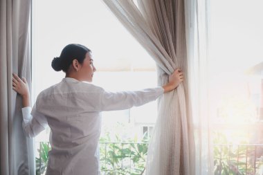 Genç ve yakışıklı garson kafenin camlarını silmek için sprey tutuyordu. Restoranı temizliyordu. Gülümseyen işçi kameraya doğru püskürtüyordu..