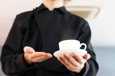 Genç ve yakışıklı garson kafenin camlarını silmek için sprey tutuyordu. Restoranı temizliyordu. Gülümseyen işçi kameraya doğru püskürtüyordu..