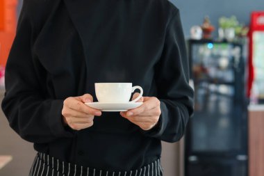 Barista 'nın elleri kafe' de bir fincan sıcak kahve tutuyor, garsonlar kahve dükkanındaki müşterilere kahve servisi yapıyor, restoranda içki içen bir adam..