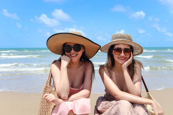 모자를 아름다운 아시아 친구와 해변에 휴식을 취하며 즐거운 시간을 보내고 — 스톡 사진