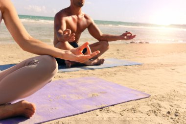 El hareketini kapat yaz plajında nilüfer pozisyonunda yoga yaparken, tropikal okyanus mavi denizinde meditasyon yaparken, sporcular egzersiz yaparken, dışarıda antrenman yaparken,  
