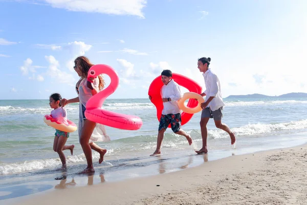 Crianças Com Pais Vestindo Anel Natação Inflável Colorido Correndo Praia — Fotografia de Stock