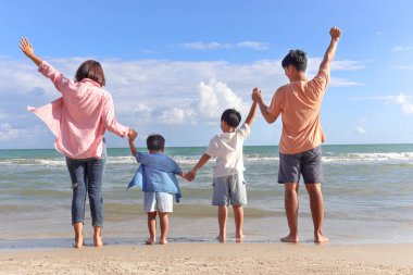 Mutlu dört aile yaz tatilinde birlikte vakit geçirir ve eğlenir. Neşeli ebeveynler, çocuklar tropikal deniz kumları kumsalında el ele tutuşur, dinlenir ve rahatlatıcı bir hafta sonu geçirirler..