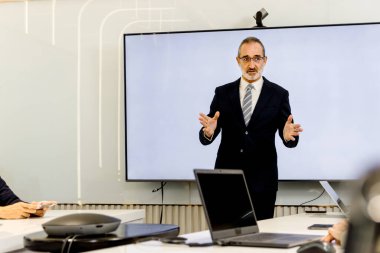 Seminer konferansında iş adamları tartışıyor. Konuşmacı izleyicilerle deneyimleri paylaşıyor ve eğitiyor. Başarılı kıdemli yaşlı işadamı toplantıda sunum yapıyor, grup yönetim kurulu beyin fırtınası