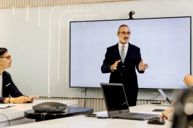 Seminer konferansında iş adamları tartışıyor. Konuşmacı izleyicilerle deneyimleri paylaşıyor ve eğitiyor. Başarılı kıdemli yaşlı işadamı toplantıda sunum yapıyor, grup yönetim kurulu beyin fırtınası