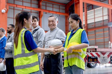 Çeşitli mühendislerin yöneticisi imalat fabrikasındaki ekiple tokalaşıyor. Lider, sanayi bölgesinde sırada bekleyen bir grup işçiyle el sıkışıyor. İşçi yöneticisinin toplantı sırasında el sıkışması var.