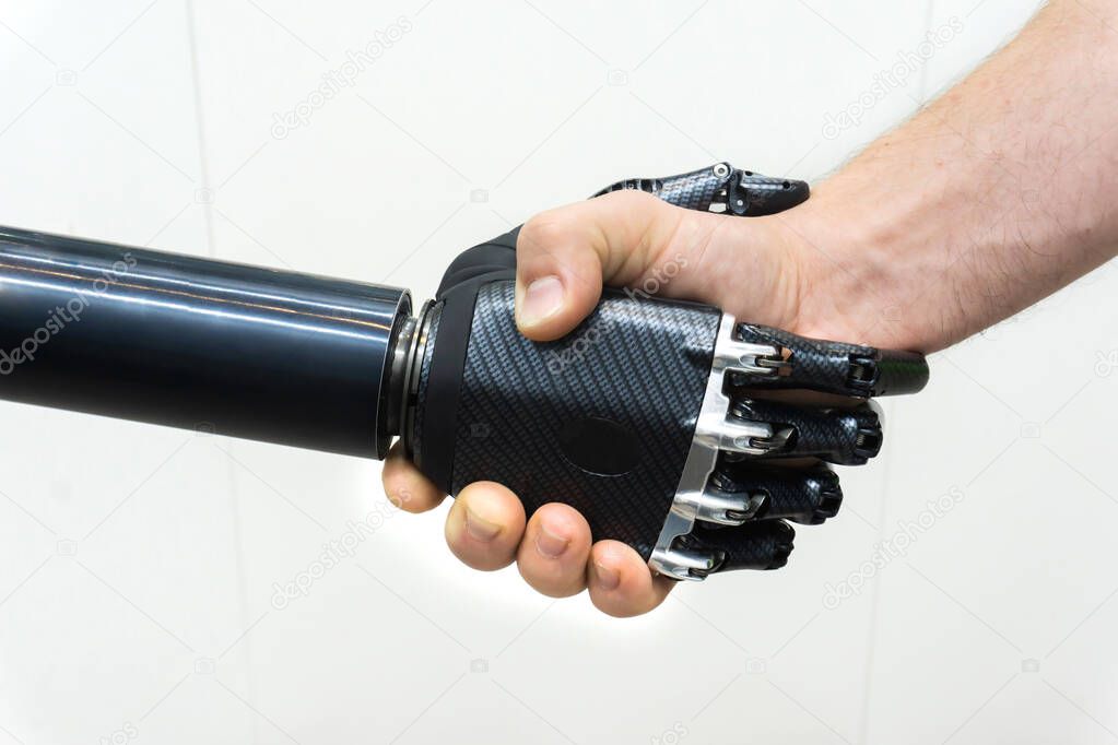 Bionic hand. Handshake of a robot and a man.