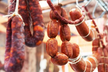 Sosis mağazadaki tezgahta asılı. Et lezzetleri ticareti. Yakın plan.