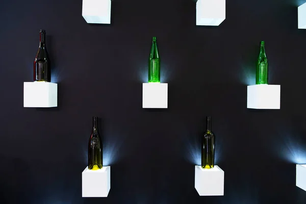 Butelki Szklane Różnych Typów Małych Półkach Pod Ścianą Wystawa Wyrobów — Zdjęcie stockowe