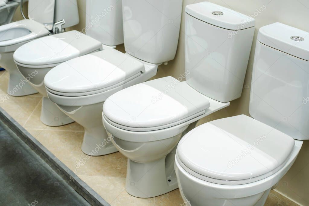 Lots of ceramic toilets in a plumbing store. Trade in equipment for bathrooms. Close-up