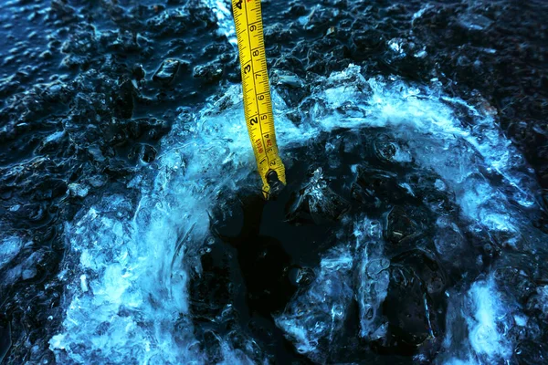 冬季钓鱼 用尺子测量冰层厚度的过程 以便在冰冷的水面上安全移动 后续行动 — 图库照片