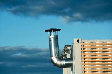 Metal bir kapta paslanmaz çelik baca. Oda havalandırması için bir dal borusu olan bir değişim evinin parçası. Yakın plan.