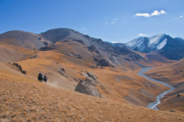 Üç avcılar ata Tien Shan dağlarında — Stok fotoğraf