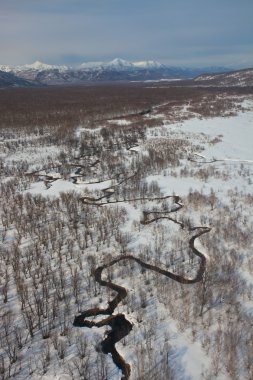 Floodplain of the river meanders in a mountain snowy tundra clipart