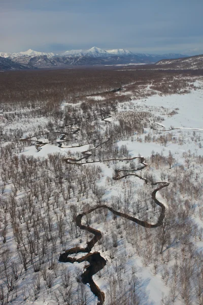 Flodslätt floden slingrar sig i ett berg snöiga tundra — Stockfoto