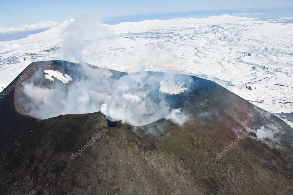 View of the mouth of an active Karymsky volcano from a helicopter