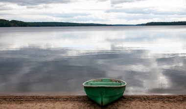 Yazın Kuzey Gölü kıyısında bulutlu, sessiz bir gün. Pionersky Gölü 'nün kıyısı ve suyu Ağustos ayının bulutlu bir yaz gününde. 