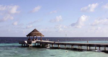 Gökyüzü manzarasının arka planında deniz tekneleri ve yatlar için rıhtım. Tropikal bir okyanus adasındaki kaleler üzerine inşa edilmiş deniz gemileri için iskele.. 